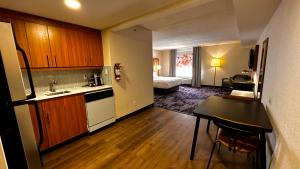 a room with a kitchen and a bedroom with a bed at Newmarket Hotel and Suites in Newmarket