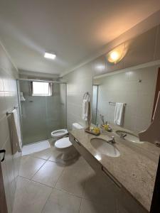 a bathroom with a sink and a toilet and a shower at Apartamento na Vila La Torre in Porto Seguro