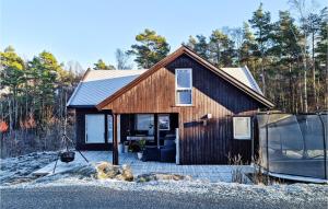 una pequeña casa de madera con porche cubierto en Pet Friendly Home In Lyngdal With Kitchen, en Lyngdal