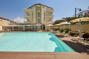 une grande piscine en face d'un hôtel dans l'établissement Grand Hotel, à Forte dei Marmi