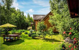 - un jardin avec une table de pique-nique et un parasol dans l'établissement 1 Bedroom Lovely Apartment In Klecino, à Klęcino