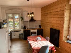 cocina con mesa y mantel rojo y blanco en L'apparté de G, Gîte 3 étoiles de montagne cosy, en Gérardmer