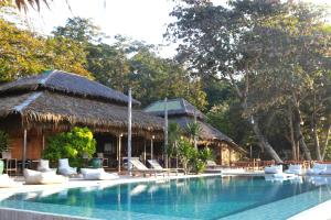a pool at a resort with chairs and a building at Koh Munnork Private Island in Ko Munnork
