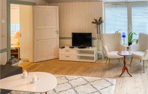 a living room with a tv and a table and chairs at Amazing Apartment In Trans With Internet And 2 Bedrooms in Tranås