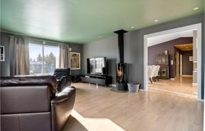uma sala de estar com mobiliário de couro e uma televisão de ecrã plano em Beautiful Apartment In Nesttun With House A Panoramic View em Bergen