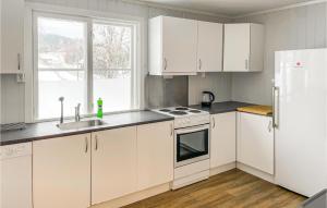 Mesnali的住宿－Gorgeous Apartment In Mesnali With Kitchen，厨房配有白色橱柜、水槽和冰箱。