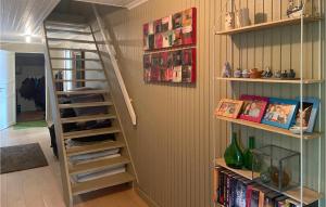 a staircase in a room with bookshelves at Stunning Home In Mosterhamn With Kitchen in Mosterhamn