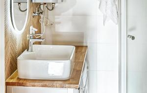 a bathroom with a white sink and a mirror at Cozy Home In Trzesacz With Kitchen in Trzęsacz