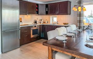 a kitchen with a wooden table and a stainless steel refrigerator at Beautiful Home In Noresund With Wifi in Noresund