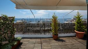 een balkon met 2 potplanten en een hek bij Loft by Clever in Thessaloniki
