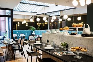a restaurant with tables and chairs and a counter with food at Holiday Inn Paris Palais de l'Elysée by IHG in Paris