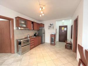 a large kitchen with wooden cabinets and stainless steel appliances at 50m-to-Sea Holiday Apartment Norwegian Village in Đenovići