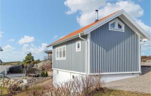 ein kleines grau-weißes Gebäude mit orangefarbenem Dach in der Unterkunft Lovely Home In Tanumshede With Kitchen in Tanumshede