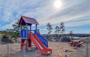 a playground with a slide in the sand at Lovely Home In Tanumshede With Kitchen in Tanumshede