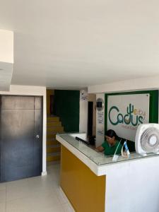 a woman sitting at a counter in a building at cactus city hostel confort in Ríohacha