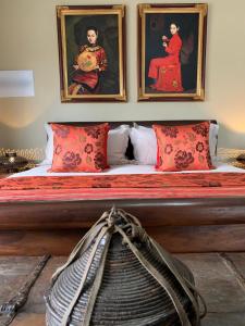 a bed with two pictures on the wall above it at Chivay Country Cottages in Rooiberg