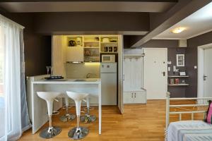 een keuken met een aanrecht en krukken in een kamer bij Loft by Clever in Thessaloniki +6 foto's