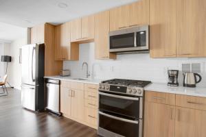 a kitchen with stainless steel appliances and wooden cabinets at Crystal City 1BR w Gym Concierge nr Metro WDC-445 in Arlington