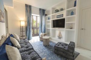 a living room with a couch and a tv at THE CLOCK HOUSE - Luxury Urban Suites in Málaga