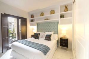 1 dormitorio con 1 cama grande y balcón en THE CLOCK HOUSE Luxury Urban Suites, en Málaga