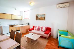 a living room with a couch and a table at Apartments Katarina k in Malinska