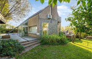 een stenen huis met glazen deuren en een tuin bij Cozy Home In Westouter With House A Panoramic View in Westouter