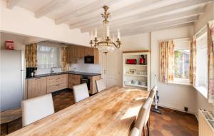 een keuken met een houten tafel en een kroonluchter bij Cozy Home In Westouter With House A Panoramic View in Westouter