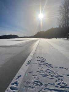 a snow covered road with the sun in the background at Lieblingsplatz in Rörvik