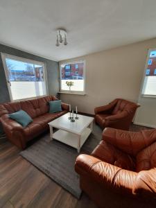 a living room with leather couches and a coffee table at Lieblingsplatz in Rörvik