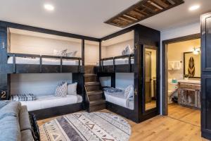 a room with three bunk beds in a house at New Rustic Luxe Cabin Billiards Spa Near GSMNP in Townsend