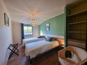 een slaapkamer met 2 bedden, een stoel en een kroonluchter bij Plenitude in Saint-Chamond