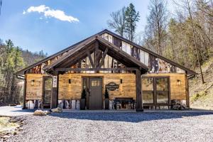 a log cabin with a front door in the mountains at New Rustic Luxe Cabin Billiards Spa Near GSMNP in Townsend