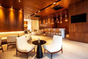 a waiting room with white chairs and a bar at Estanconfor Santos Vista Mar com AC, Garagem, alto 23º andar in Santos