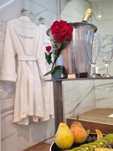 un jarrón con una rosa sobre una mesa con peras en La suite plenitude, en Saint-Chamond