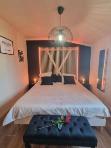 Un dormitorio con una cama grande con una flor en un banco en La suite plenitude, en Saint-Chamond