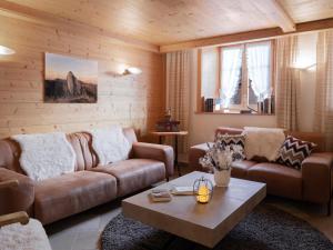 a living room with two couches and a coffee table at Hotel de Commune in Gstaad