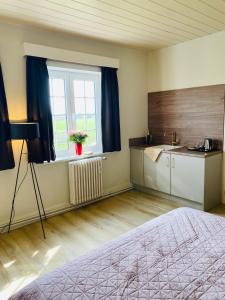 um quarto com uma cama e uma cozinha com uma janela em Villa La Dune - Ontbijt & parking inclusief em Middelkerke