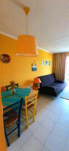 uma sala de estar com uma mesa e um sofá em Super-cute colourful, cozy flat em Saint-Raphaël