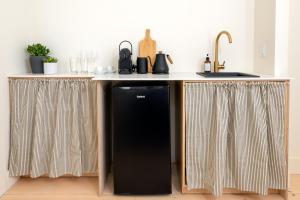 a kitchen with a black refrigerator under a counter at The August House in Windsor +35 photos