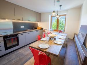 uma cozinha com uma mesa de madeira e cadeiras vermelhas em Chalet Méribel, 5 pièces, 10 personnes - FR-1-688-17 em Méribel