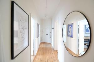 a hallway with a round mirror on a wall at Large & Stylish Flats in Trendy & Vibrant Neighbourhood in Copenhagen