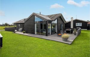uma casa preta com uma grande janela e relva verde em Cozy Home In Sby With House Sea View em Sæby