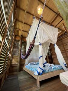 a bed with a hammock in a room at Palmayacu - Refugio Amazónico in Leticia