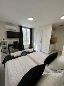 a large bedroom with a large bed with black pillows at Kimi Résidence in Cannes