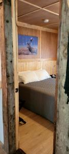 ein Schlafzimmer mit einem Bett mit einem Hirschgemälde an der Wand in der Unterkunft Motel du Haut Phare in Cap-des-Rosiers