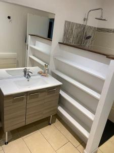 a bathroom with a sink and a mirror and a shower at Magnifique T2 en bord de mer in Le Lavandou