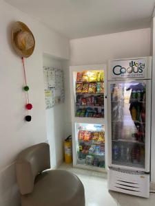 Zimmer mit einem Kühlschrank und einem Stuhl davor in der Unterkunft cactus city hostel confort in Ríohacha