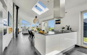 uma cozinha com armários brancos e uma sala de jantar em Cozy Home In Sby With House Sea View em Sæby