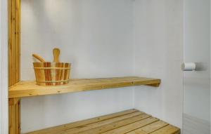 a wooden shelf with a basket and two wooden spoons at Holiday Home Strandgården in Sæby +20 photos