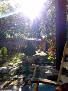 a bench in a garden with the sun shining at Posada Real El Rincón de Babia in La Cueta